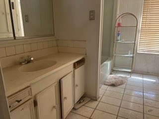 1302 S Texas Ave, Odessa, TX 79761 - full bath featuring vanity, tile patterned flooring, shower / tub combination, and backsplash
