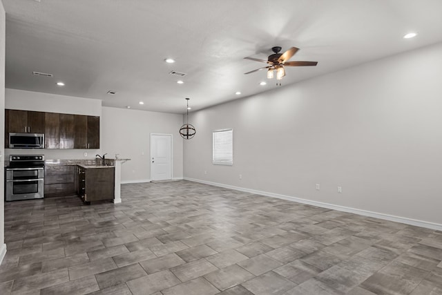 2227 W 3rd St, Odessa, TX 79763 - kitchen featuring stainless steel appliances, open floor plan, recessed lighting, dark brown cabinetry, and light countertops