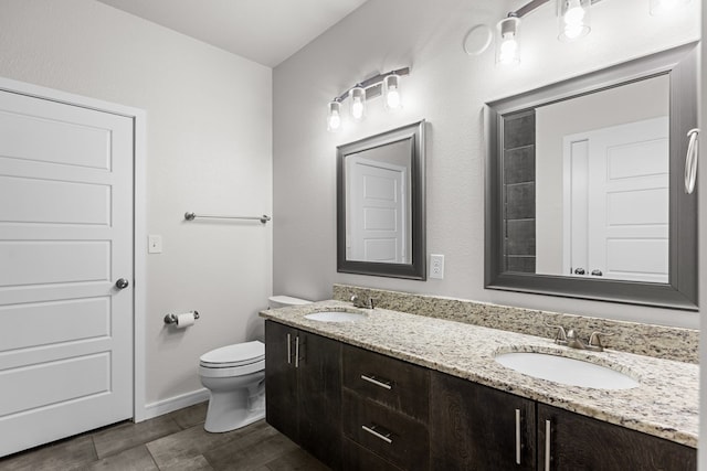 2227 W 3rd St, Odessa, TX 79763 - bathroom featuring toilet, double vanity, and baseboards