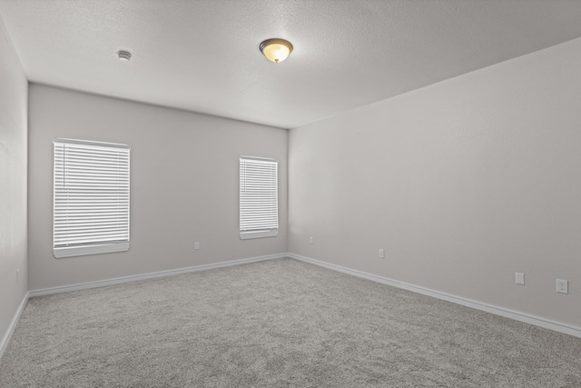2227 W 3rd St, Odessa, TX 79763 - spare room with carpet flooring, a textured ceiling, and baseboards