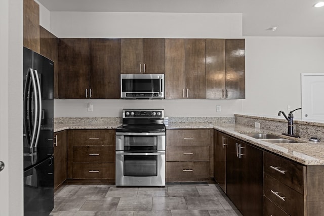 2227 W 3rd St, Odessa, TX 79763 - kitchen with appliances with stainless steel finishes, a sink, dark brown cabinets, and a peninsula