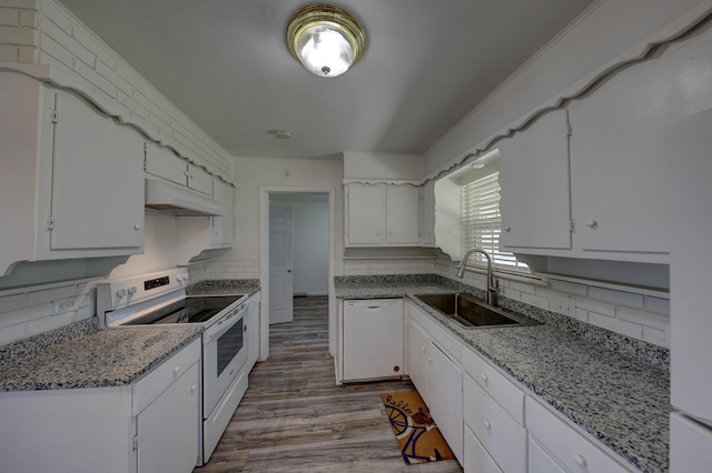 1500 S Bruce Ave, Monahans, TX 79756 - kitchen with white appliances, tasteful backsplash, white cabinetry, and wood finished floors