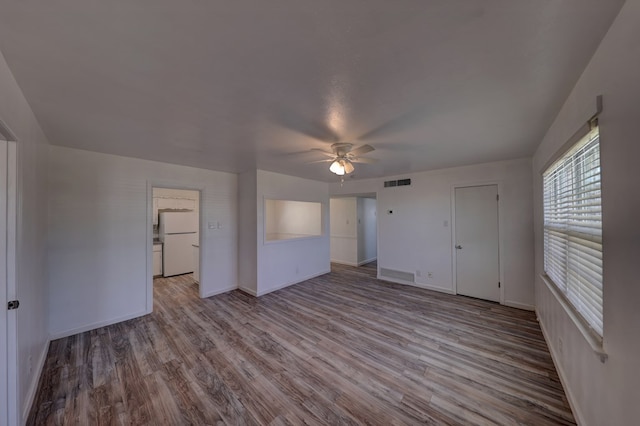 1500 S Bruce Ave, Monahans, TX 79756 - unfurnished bedroom with freestanding refrigerator, wood finished floors, and ceiling fan