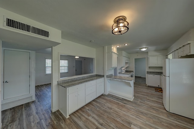 1500 S Bruce Ave, Monahans, TX 79756 - kitchen with white appliances, white cabinets, wood finished floors, and light stone counters