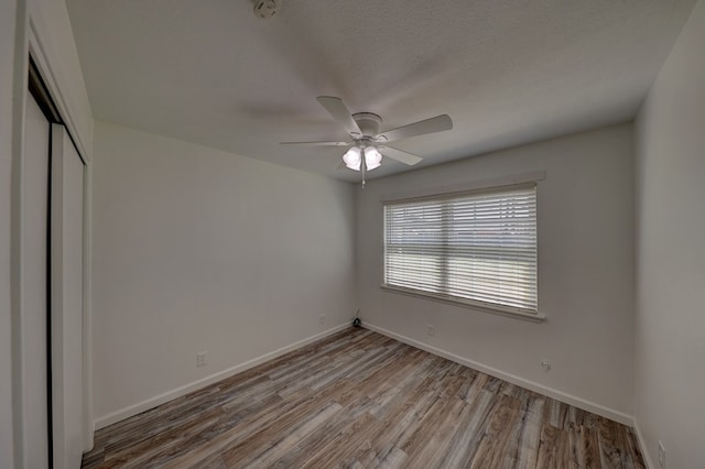 1500 S Bruce Ave, Monahans, TX 79756 - unfurnished bedroom featuring a closet, wood finished floors, and ceiling fan