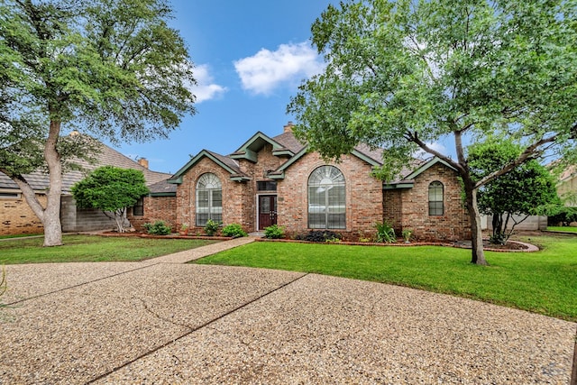 6415 San Mateo Ln, Odessa, TX 79762 - view of front of property featuring brick siding, a chimney, and a front yard
