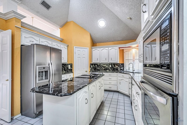 6415 San Mateo Ln, Odessa, TX 79762 - kitchen with stainless steel appliances, light tile patterned flooring, a center island, white cabinets, and decorative backsplash