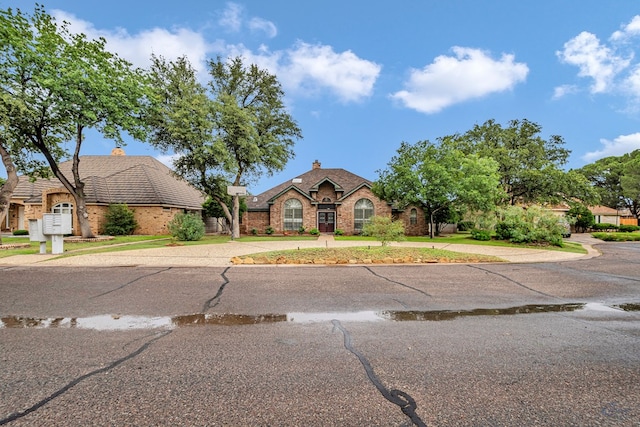 6415 San Mateo Ln, Odessa, TX 79762 - view of front of home featuring a chimney, brick siding, and concrete driveway