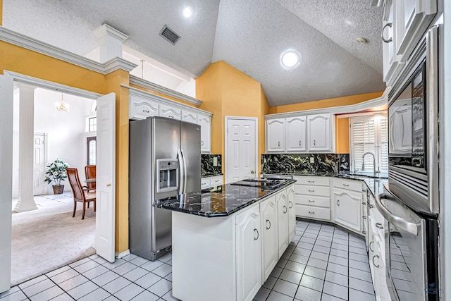 6415 San Mateo Ln, Odessa, TX 79762 - kitchen with appliances with stainless steel finishes, a kitchen island, light tile patterned flooring, healthy amount of natural light, and a textured ceiling