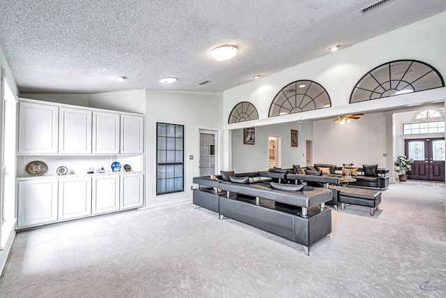 6415 San Mateo Ln, Odessa, TX 79762 - living room featuring carpet floors, a textured ceiling, french doors, and high vaulted ceiling