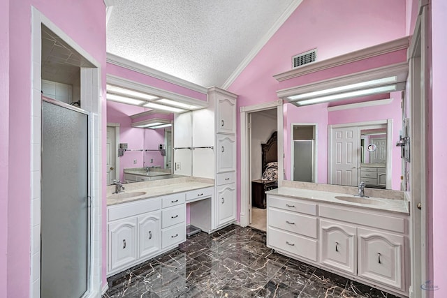 6415 San Mateo Ln, Odessa, TX 79762 - bathroom with lofted ceiling, a stall shower, a textured ceiling, two vanities, and ornamental molding