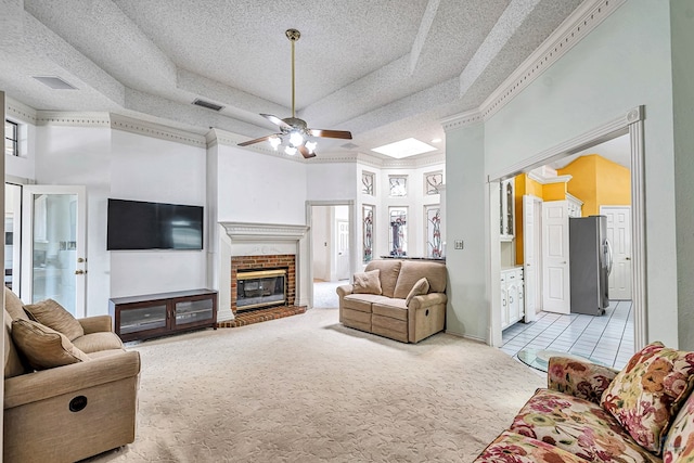 6415 San Mateo Ln, Odessa, TX 79762 - living room featuring light colored carpet, a high ceiling, a tray ceiling, ceiling fan, and a brick fireplace