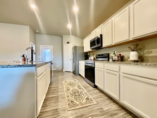 1311 Red Cliff Ave, Odessa, TX 79765 - kitchen featuring stainless steel appliances, light wood finished floors, white cabinetry, stone counters, and lofted ceiling