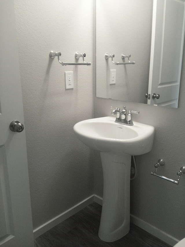 bathroom with baseboards, a sink, and wood finished floors