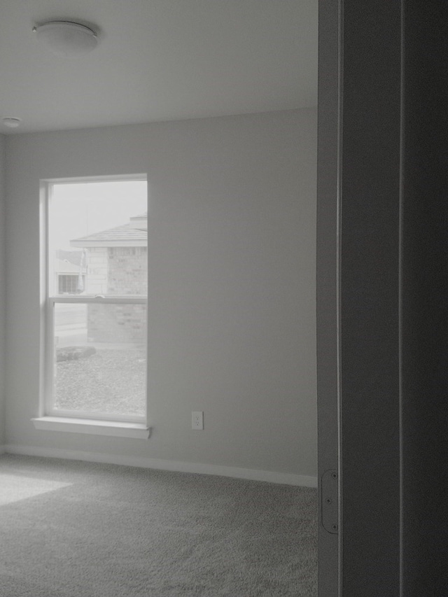 carpeted empty room with baseboards