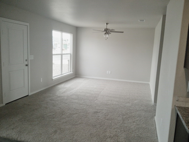 unfurnished living room with baseboards, a ceiling fan, carpet, and visible vents
