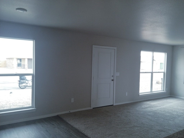 carpeted spare room featuring baseboards