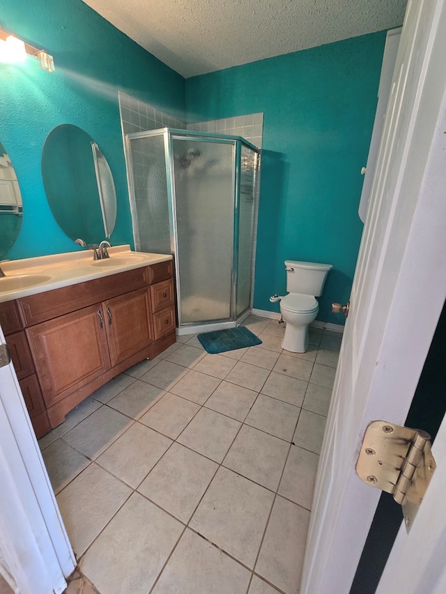 3613 Locust Ave, Odessa, TX 79762 - bathroom featuring a textured ceiling, vanity, a stall shower, and tile patterned floors