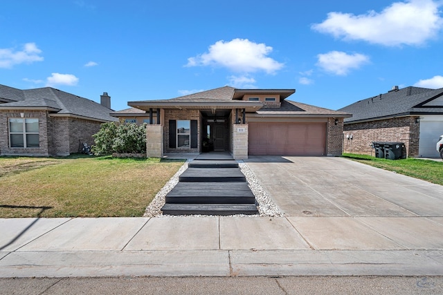 811 E 97th Ct, Odessa, TX 79765 - prairie-style home with brick siding, an attached garage, driveway, a front yard, and a shingled roof