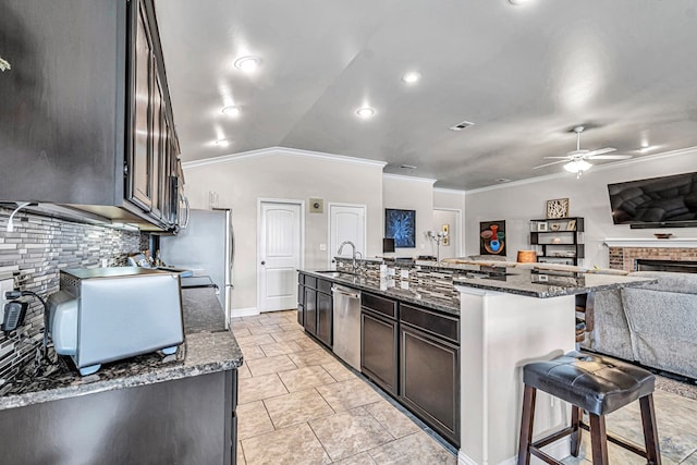811 E 97th Ct, Odessa, TX 79765 - kitchen featuring ceiling fan, stainless steel appliances, backsplash, open floor plan, and a kitchen bar