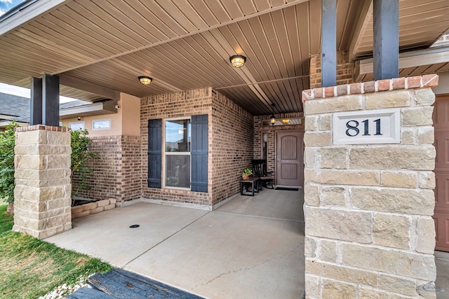 811 E 97th Ct, Odessa, TX 79765 - doorway to property with brick siding and a patio area