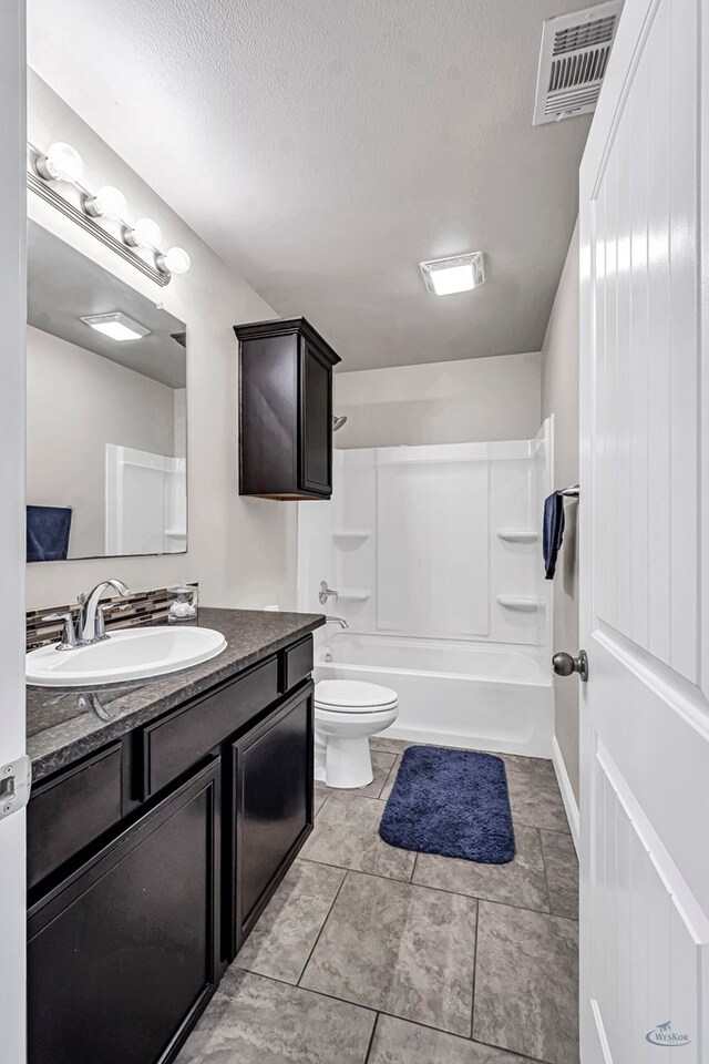 811 E 97th Ct, Odessa, TX 79765 - full bathroom with vanity, toilet, washtub / shower combination, a textured ceiling, and tile patterned floors