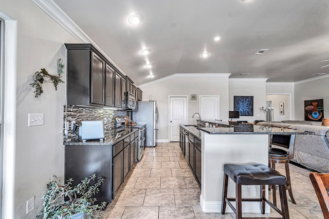 811 E 97th Ct, Odessa, TX 79765 - kitchen with stainless steel appliances, dark stone counters, open floor plan, tasteful backsplash, and ornamental molding
