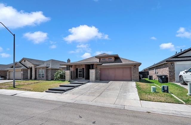 811 E 97th Ct, Odessa, TX 79765 - view of front facade featuring brick siding, a front yard, a garage, a shingled roof, and driveway