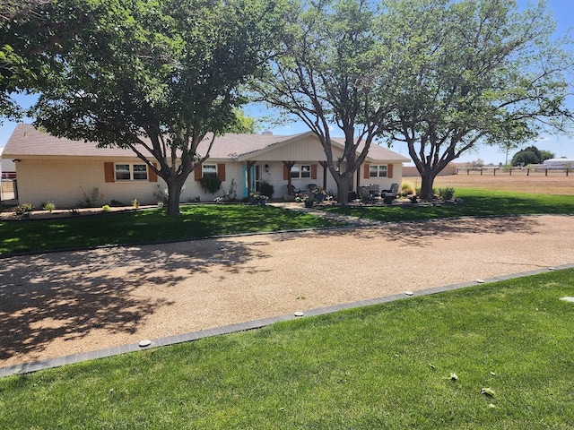 ranch-style house featuring a front lawn and brick siding