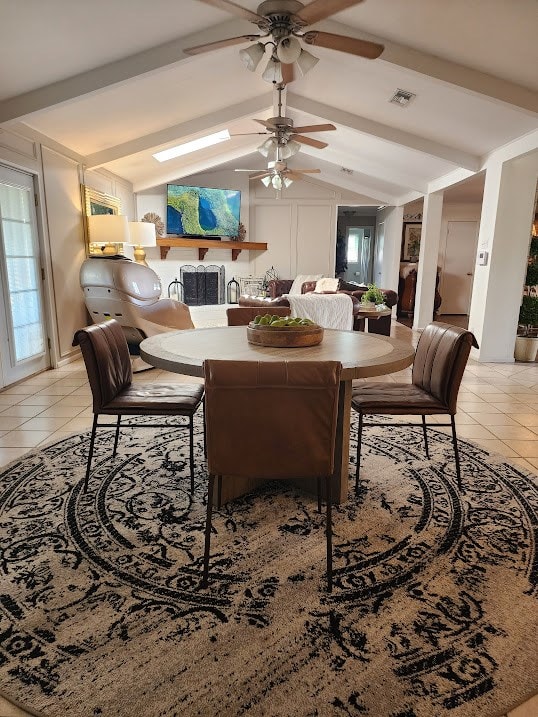 dining space with a ceiling fan, lofted ceiling with beams, light tile patterned floors, and visible vents