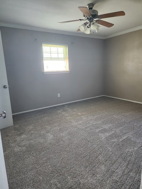 empty room with ceiling fan, ornamental molding, carpet, and baseboards