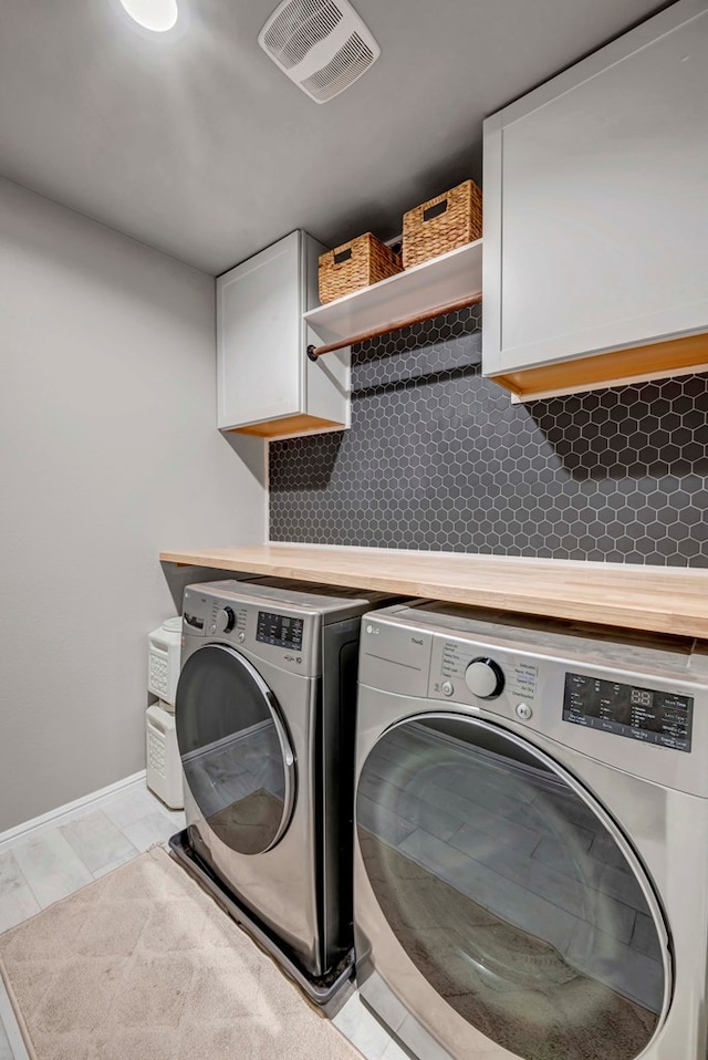 8409 E County Rd 115, Midland, TX 79706 - washroom featuring separate washer and dryer, cabinet space, and baseboards