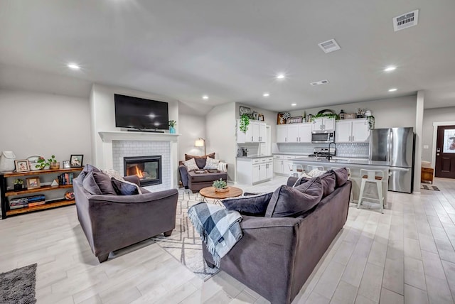 8409 E County Rd 115, Midland, TX 79706 - living room with light wood-style flooring, a fireplace, and recessed lighting