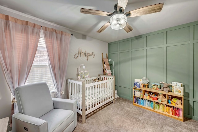 8409 E County Rd 115, Midland, TX 79706 - bedroom with a nursery area, multiple windows, carpet floors, a decorative wall, and a ceiling fan