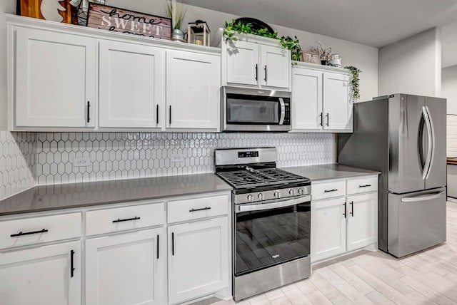 8409 E County Rd 115, Midland, TX 79706 - kitchen with appliances with stainless steel finishes, white cabinetry, decorative backsplash, and light wood finished floors
