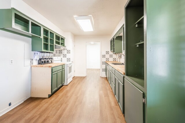 309 SW 10th St, Andrews, TX 79714 - kitchen featuring white range with electric stovetop, green cabinets, open shelves, under cabinet range hood, and light wood-style flooring