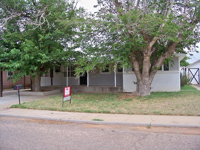 309 SW 10th St, Andrews, TX 79714 - obstructed view of property featuring brick siding and a front lawn