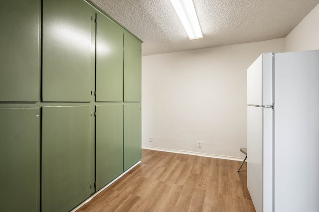 309 SW 10th St, Andrews, TX 79714 - kitchen featuring freestanding refrigerator, green cabinets, and light wood-type flooring
