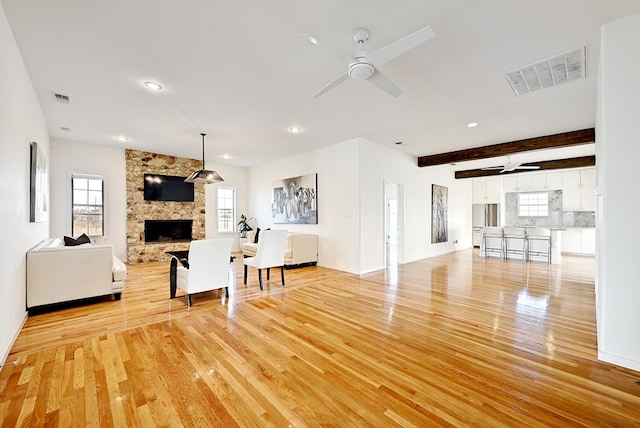 1007 E Texas St, Marfa, TX 79843 - living room with ceiling fan, a stone fireplace, light wood-style floors, beamed ceiling, and recessed lighting