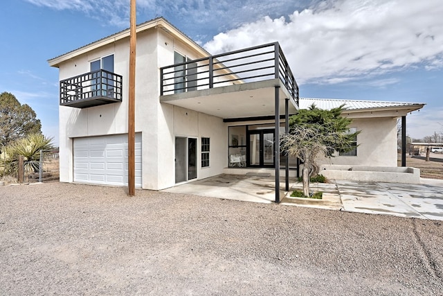 1007 E Texas St, Marfa, TX 79843 - back of house with a balcony, an attached garage, stucco siding, and a patio area