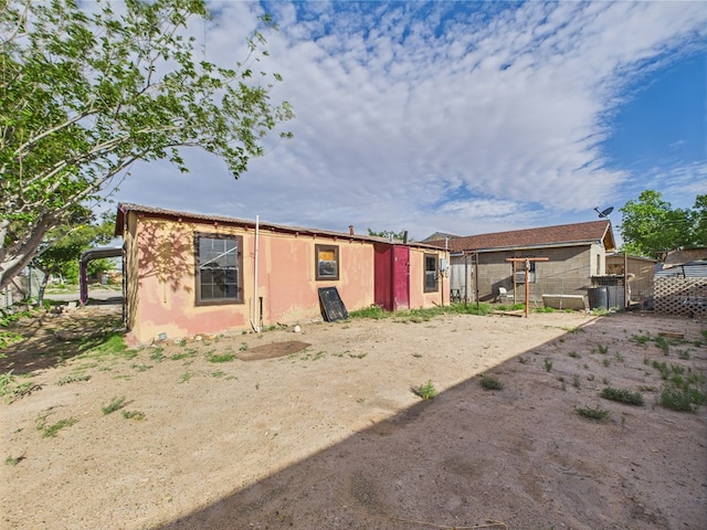 back of property featuring stucco siding