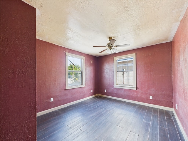 unfurnished room featuring dark wood-style floors, ceiling fan, a textured ceiling, baseboards, and a textured wall