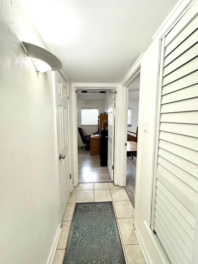 503 E Hendryx Ave, Alpine, TX 79830 - corridor featuring light tile patterned floors, a textured ceiling, baseboards, and an office area