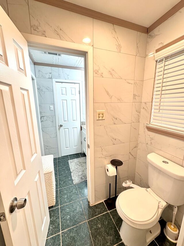503 E Hendryx Ave, Alpine, TX 79830 - bathroom with toilet, tile walls, and tile patterned flooring