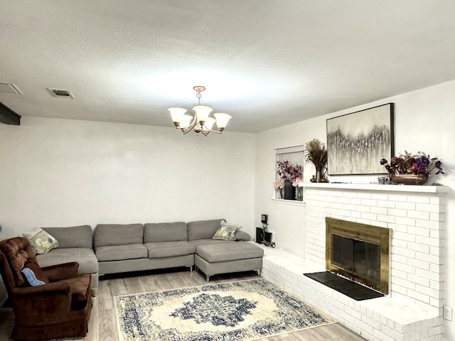 503 E Hendryx Ave, Alpine, TX 79830 - living area with light wood-style floors, a chandelier, a fireplace, and a textured ceiling