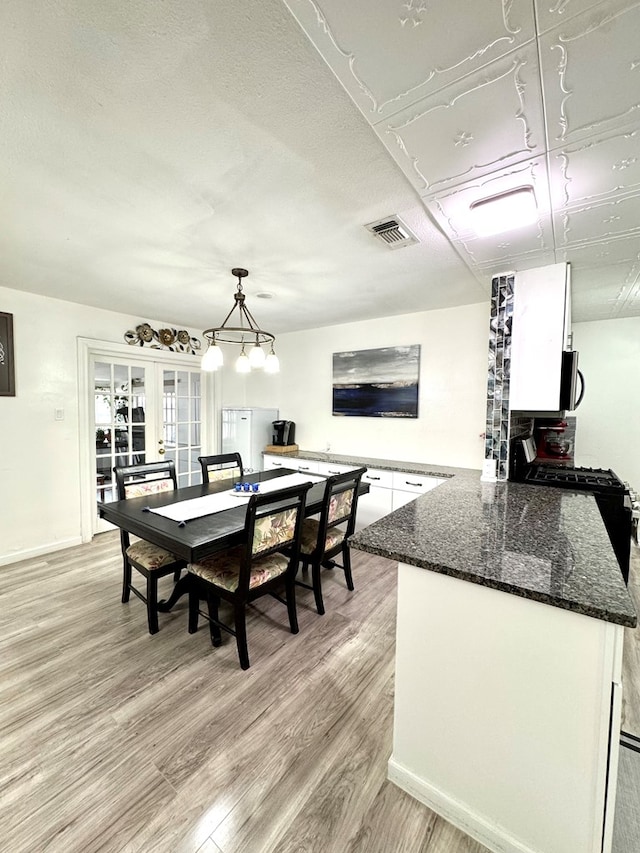 503 E Hendryx Ave, Alpine, TX 79830 - dining area featuring light wood-style flooring, baseboards, and a chandelier