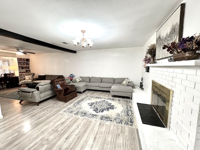 503 E Hendryx Ave, Alpine, TX 79830 - living room featuring a fireplace, a textured ceiling, a chandelier, wood finished floors, and beam ceiling