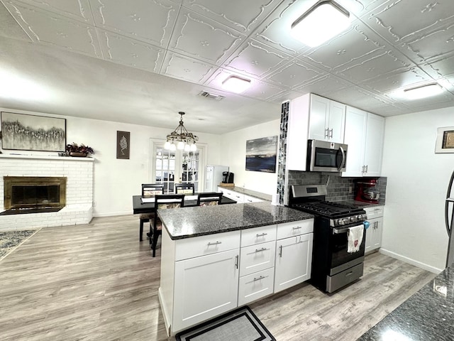503 E Hendryx Ave, Alpine, TX 79830 - kitchen with stainless steel appliances, white cabinetry, an ornate ceiling, a peninsula, and light wood-style floors