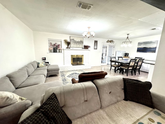 503 E Hendryx Ave, Alpine, TX 79830 - living area featuring a chandelier, wood finished floors, and a brick fireplace