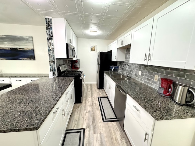 503 E Hendryx Ave, Alpine, TX 79830 - kitchen with stainless steel appliances, a sink, light wood-type flooring, an ornate ceiling, and white cabinetry